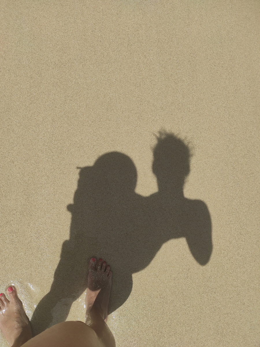 Sombra de madre con hijo sobre la arena de la playa